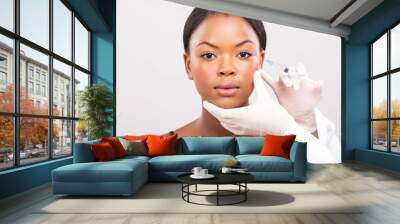 cosmetic surgeon injecting young african woman face Wall mural