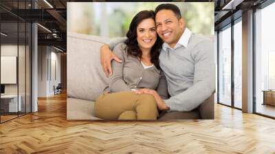 couple sitting on sofa at home Wall mural