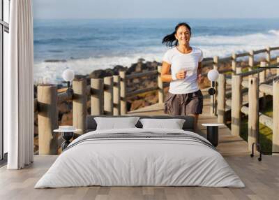 fit mid age woman jogging at the beach Wall mural