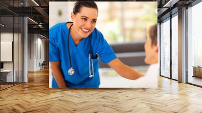 friendly young nurse talking to senior patient in hospital Wall mural