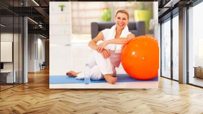 happy senior woman resting on mat after exercise at home Wall mural