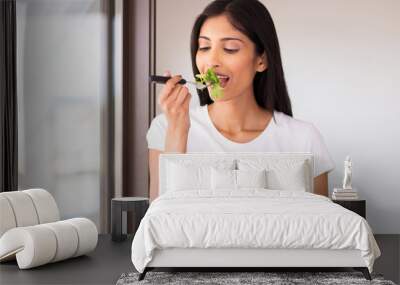 indian woman eating green salad Wall mural