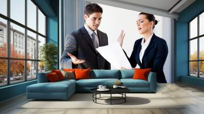 two young colleagues arguing over paperwork in office Wall mural