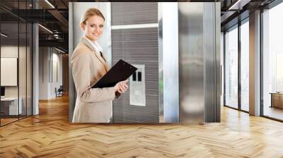 young businesswoman waiting for elevator in the building Wall mural