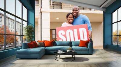 young couple holding sold sign Wall mural