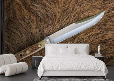 a bowie knife with an antler shank on the fur Wall mural