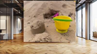 abandoned yellow bucket children's toy lying in the sand Wall mural