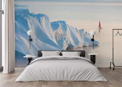 Early morning summer alpenglow lighting up icebergs during midnight season. Ilulissat, Greenland. Summer Midnight Sun and icebergs. Blue ice in icefjord. Affected by climate change and global warming. Wall mural