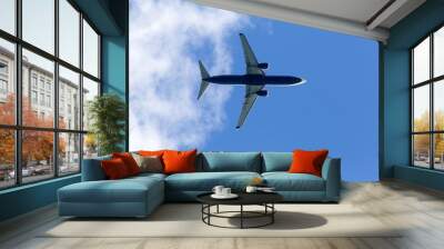 Low angle view of plane against sky, close up fling. Blue plane, low cost flights company, passenger airplane flight against blue background below view Wall mural