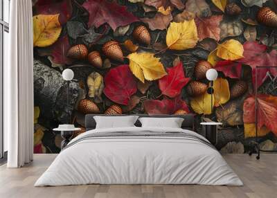 A detailed view of a cluster of acorns and bright red and yellow leaves scattered on the ground, with the rich texture of the leaves and bark visible Wall mural