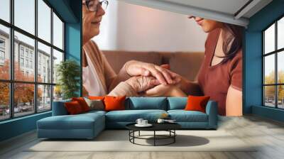 Two hands. A young woman holds the hand of an older woman. Caregiver at home. Wall mural