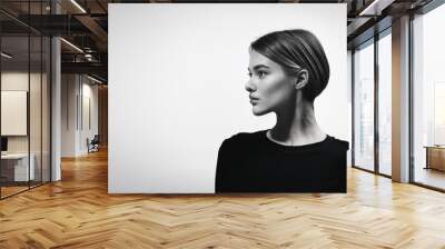 Minimalist portrait of a young woman. Wide space creating a versatile graphic image. Use in creative designs and editorial layouts. Clean composition and use of space Wall mural