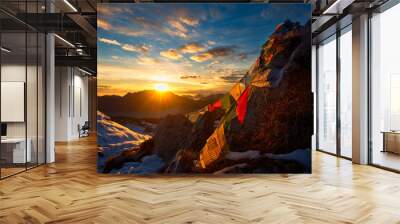 Flags of Tibetan prayers in the mountains with the colors of a warm sunset Wall mural