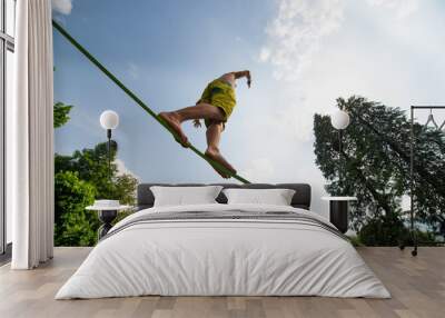 Sporty boy practices walking on the rope Wall mural