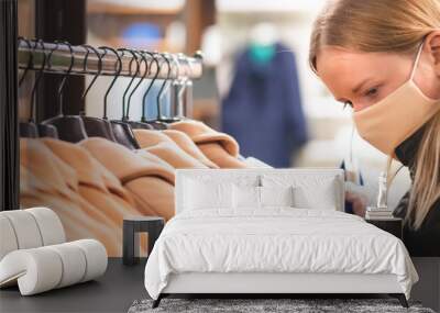 Blond girl in a shop with mask and plastic gloves, shopping during covid or coronavirus lockdown  Wall mural