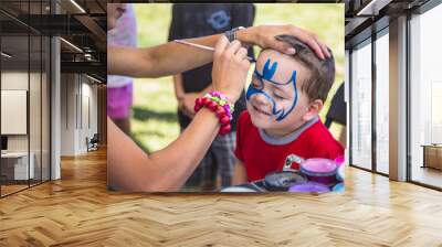 young boy getting his face painted Wall mural