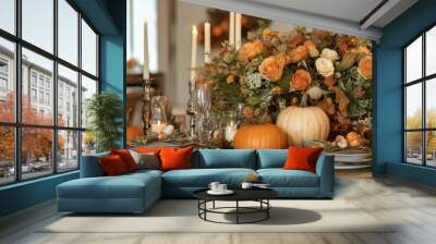 A rustic table is beautifully set for a fall gathering, featuring a centerpiece of autumnal flowers, pumpkins, and candles. The warm colors and natural elements create a cozy and inviting atmosphere. Wall mural