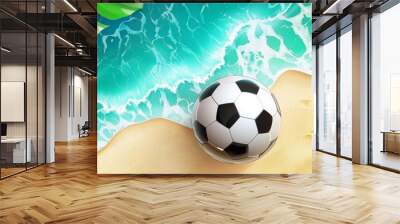 A soccer ball rests on a sandy beach, surrounded by lush tropical foliage and the glistening turquoise ocean.  The scene symbolizes vacation, sports, relaxation, nature, and summer fun. Wall mural