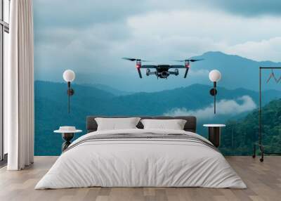 Drone Flying Over Lush Green Mountains - A drone flying over a mountain range, with lush green vegetation and a few white clouds in the sky. It symbolizes freedom, exploration, technology, nature, and Wall mural