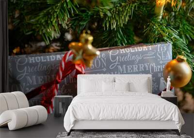 Packed Christmas present and decoration with a christmas tree in the background. Wall mural