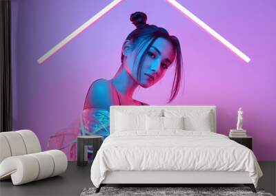 Elegant beautiful woman in a raincoat around colourful bright neon Wall mural