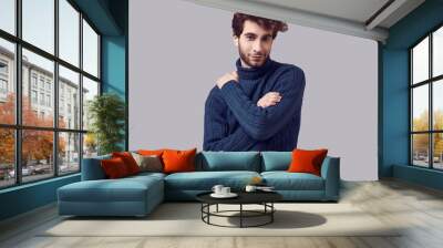 Handsome elegant man with curly hair in blue sweater Wall mural