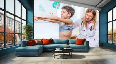 Pediatrician examining boy's spine Wall mural