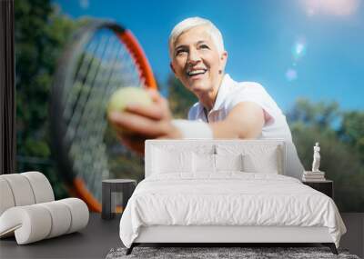 Smiling Elderly Woman Playing Tennis as a Recreational Activity Wall mural