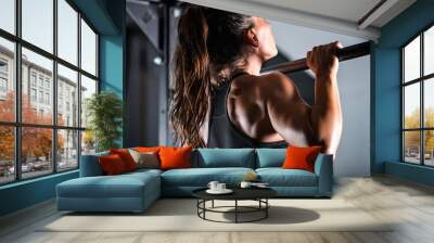 Woman athlete doing pull ups Wall mural