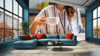 Woman drinking coffee and reading book Wall mural