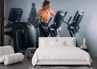 Woman Exercising on Elliptical Cross Trainer Wall mural