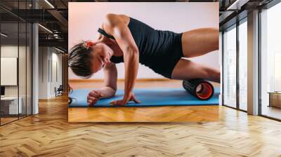 Woman Massaging Legs with Foam Roller Wall mural