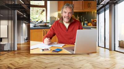 Mature Man Looking At Home Finances In Kitchen Wall mural