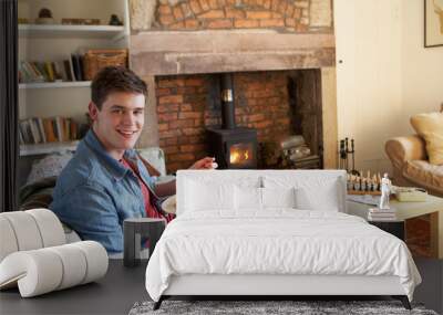 young man eating meal by fire Wall mural