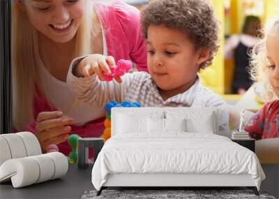 Young woman playing with boy Wall mural