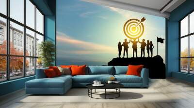 Goal setting towards planning for the future. Silhouettes of group businessmen holding target boards with flags planted on a mountain. Concept of a clear planning process and teamwork. Wall mural