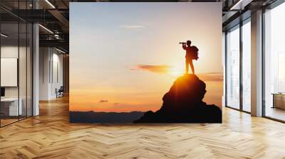 vision for success ideas. businessman's perspective for future planning. Silhouette of man holding binoculars on mountain peak against bright sunlight sky background. Wall mural