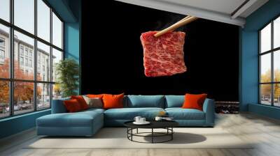 beef being lifted by chopsticks above the grill surface against a black background Wall mural