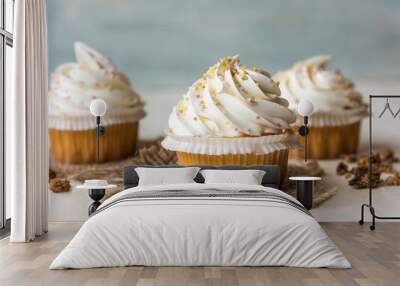 closeup of a cupcake with white frosting and sprinkles on a white surface Wall mural