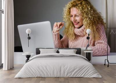 Mature woman making a video call from her laptop at home during quarantine Wall mural