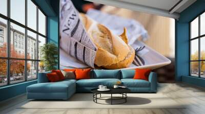 Crispy bread sandwich wrapped in newspaper. Wall mural