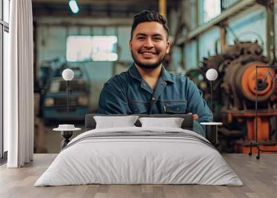 Spanish man as a mechanic posing happy inside the workshop. Wall mural