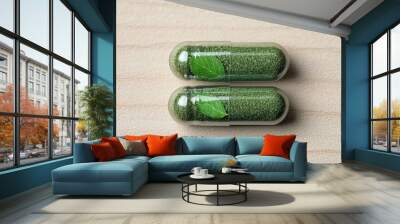 Two green capsules with visible leaves inside, representing herbal supplements Wall mural