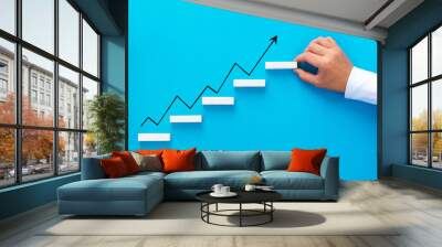 Businessman hand arranging wood block stacking as step stair with growth arrow. Business  growth success and development concept. Wall mural