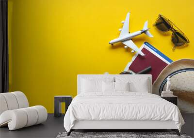 Travel accessories and objects on a yellow background with a top view and copy space. Airplane and passport, money, hat, ticket. Travel background for travel agency banner advertisement. Flat lay Wall mural