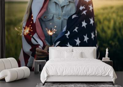 Young girl holding bengal fire with American flag at sunset. America celebrate 4th of July. Independence Day. Wall mural