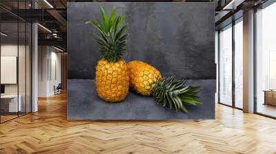 Two 2 Pineapples on a black stone table. Tropical Fruits. Wall mural