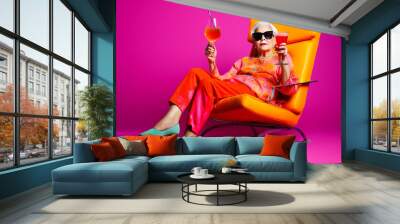 Funny old woman, chilling and relaxing in an armchair, drinking wine. Generative AI. Wall mural