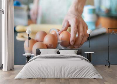 close up cook hands taking an egg while cooking f Wall mural