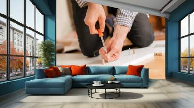 close up man assembling new furniture with a screwdriver b Wall mural